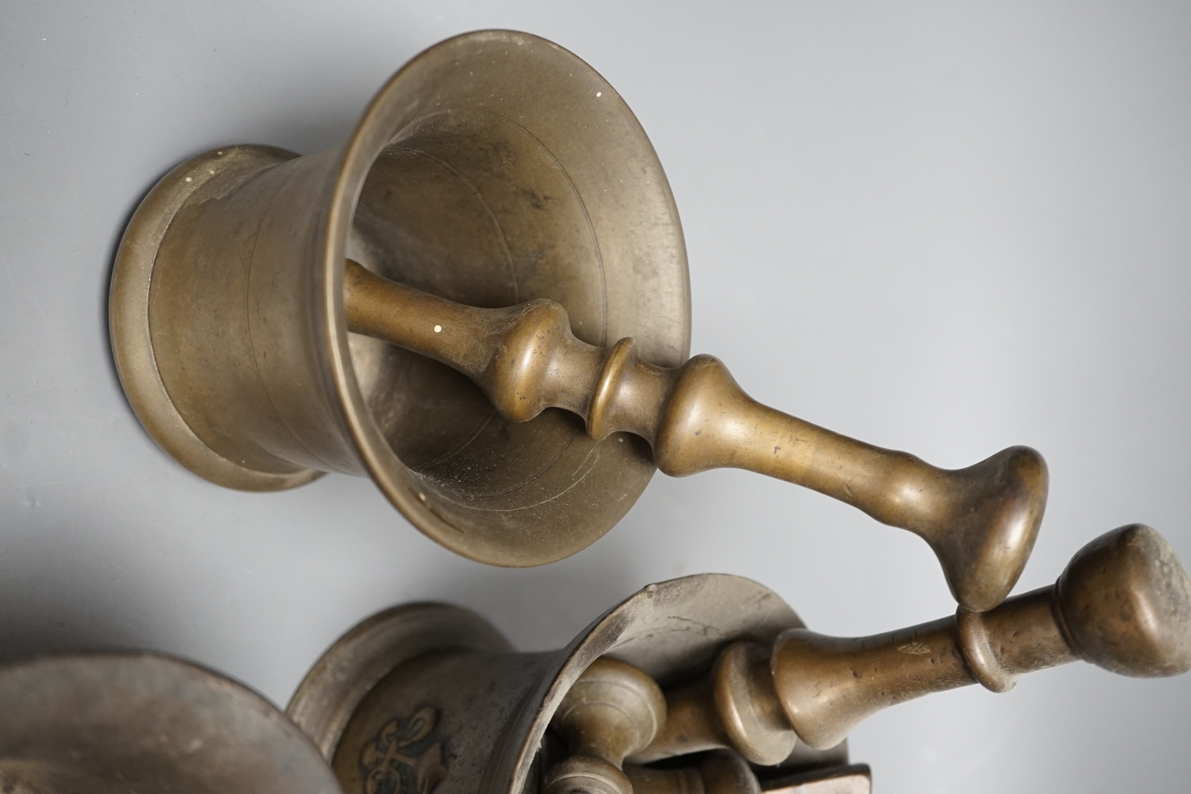 Three bell metal mortars, two pestles, a turned lignum vitae mortar and three postal weights, urn height 20cm